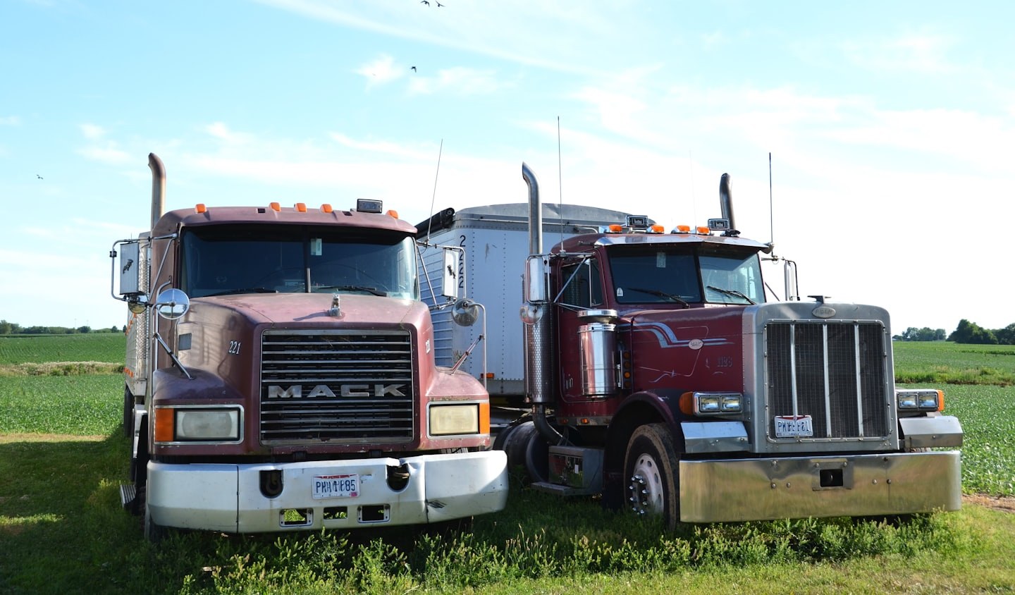 Two trucks parked in a field