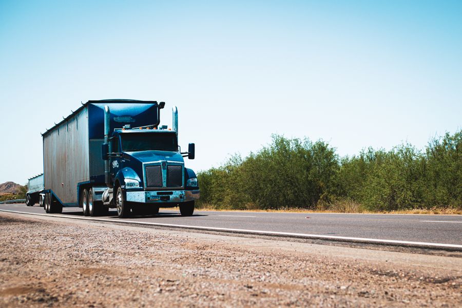 Blue semi-truck with trailer parked at the roadside
