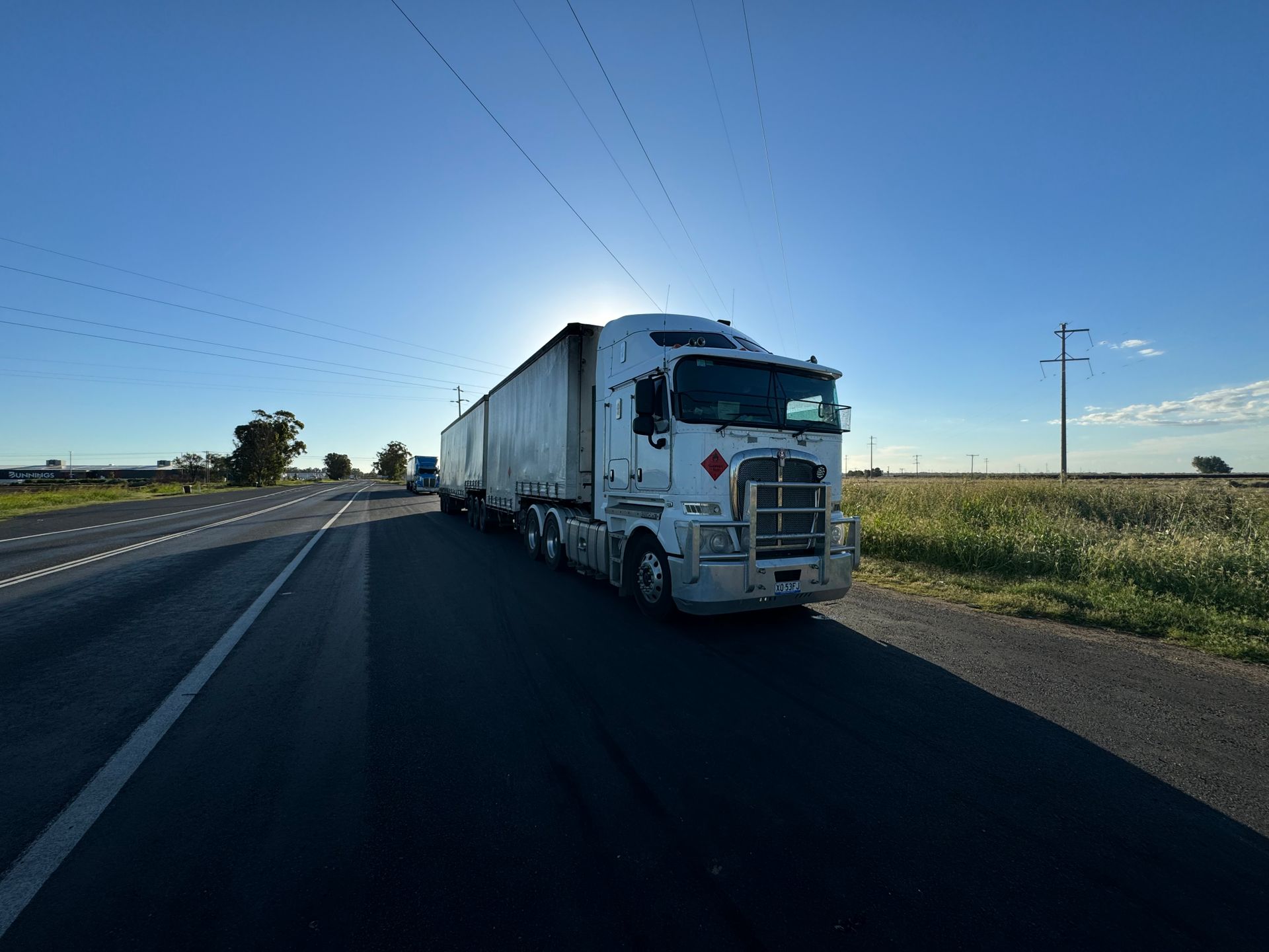 White semi-truck with a long trailer on the highway